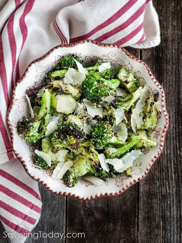 Overhead shot of grilled broccoli in a bowl on a wood table