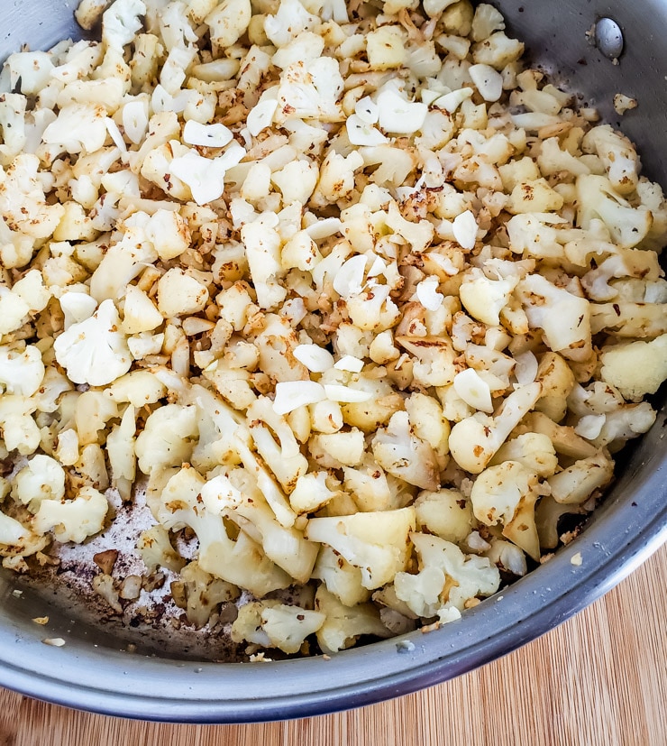 cauliflower roasting in a skillet, browning