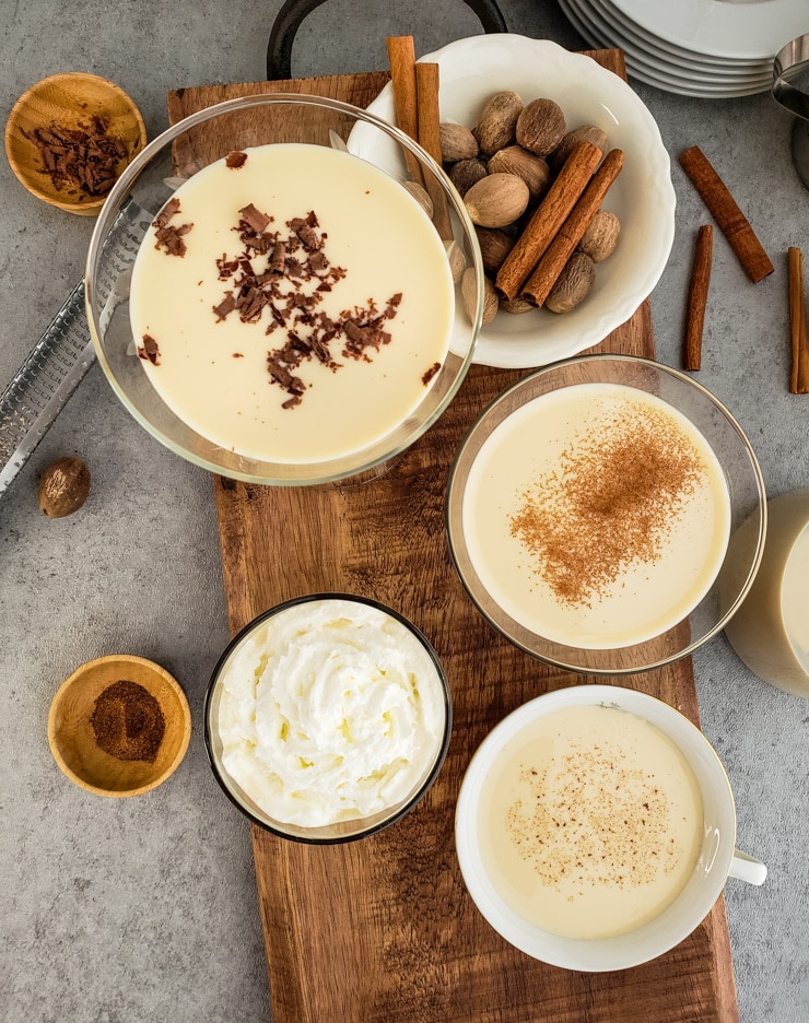 Eggnog served with whipped cream, cinnamon, nutmeg, and chocolate shavings