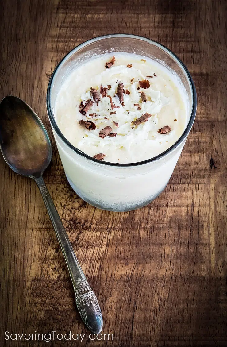 Frozen eggnog in a glass with chocolate shavings and a spoon.