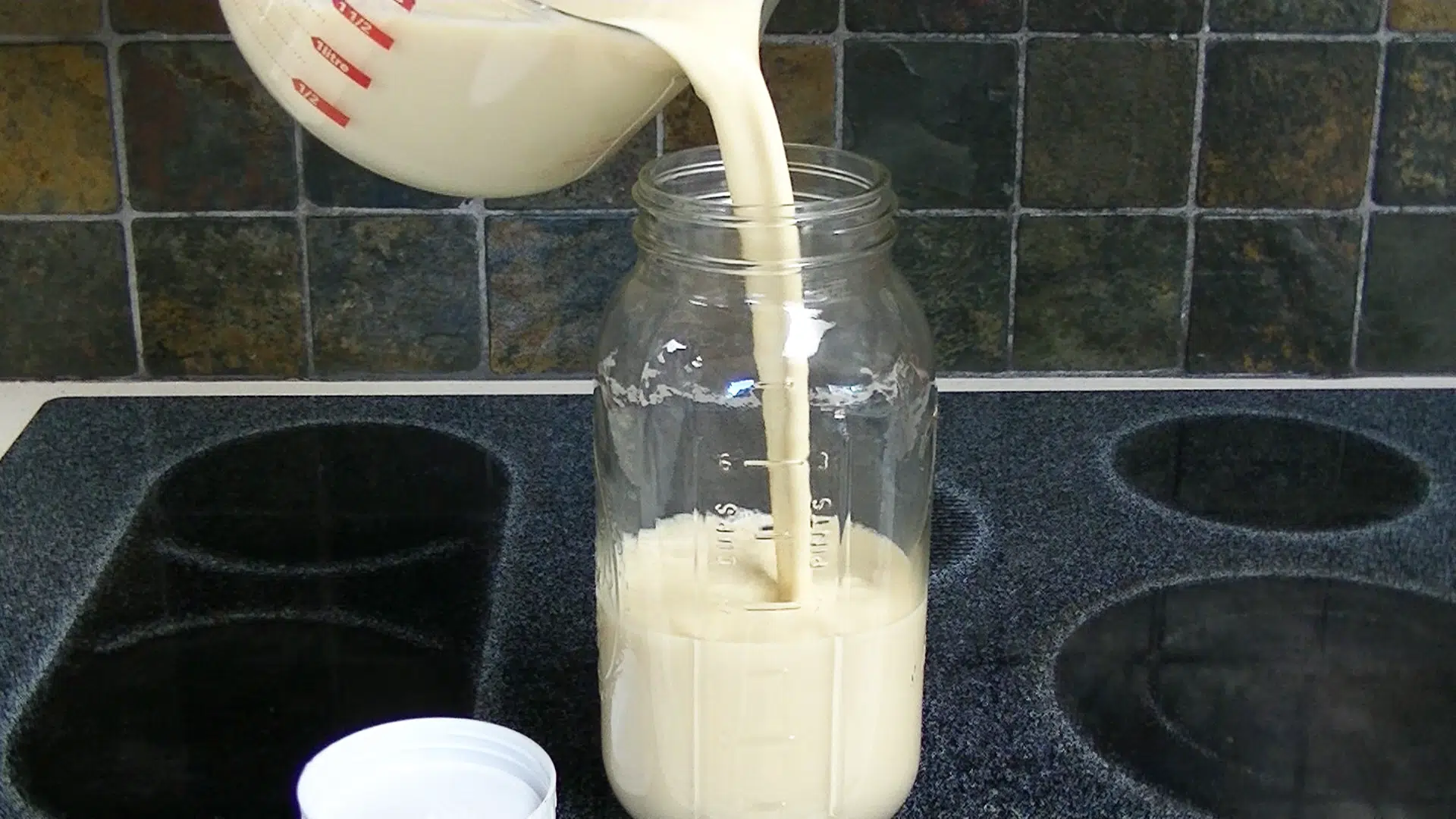 pouring custard-style eggnog into a storage jar