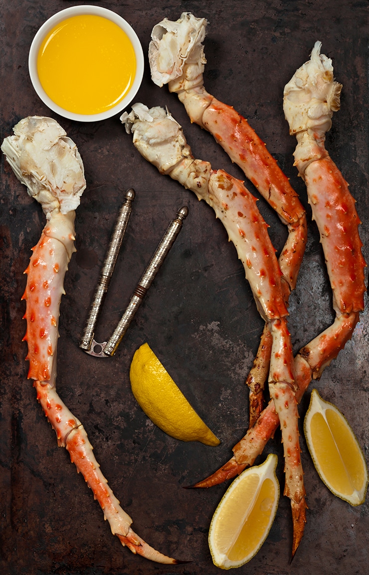crab legs on a sheet pan with lemon and crab tool