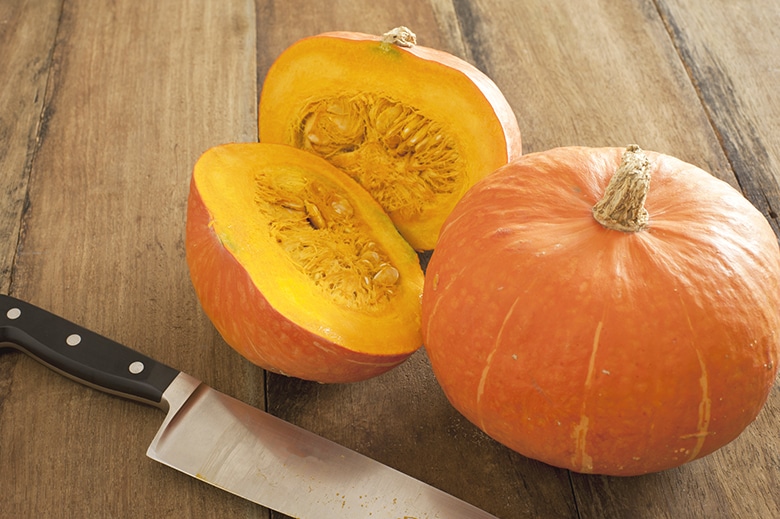 small sugar pumpkin cut in half on a table