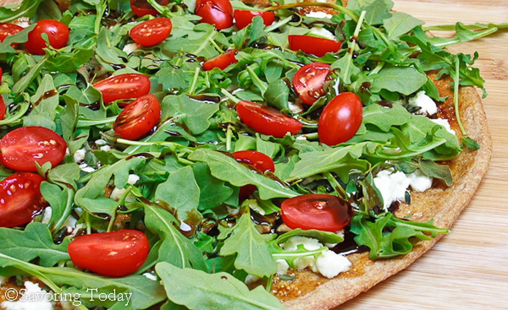 pizza with arugula, tomatoes, and goat cheese