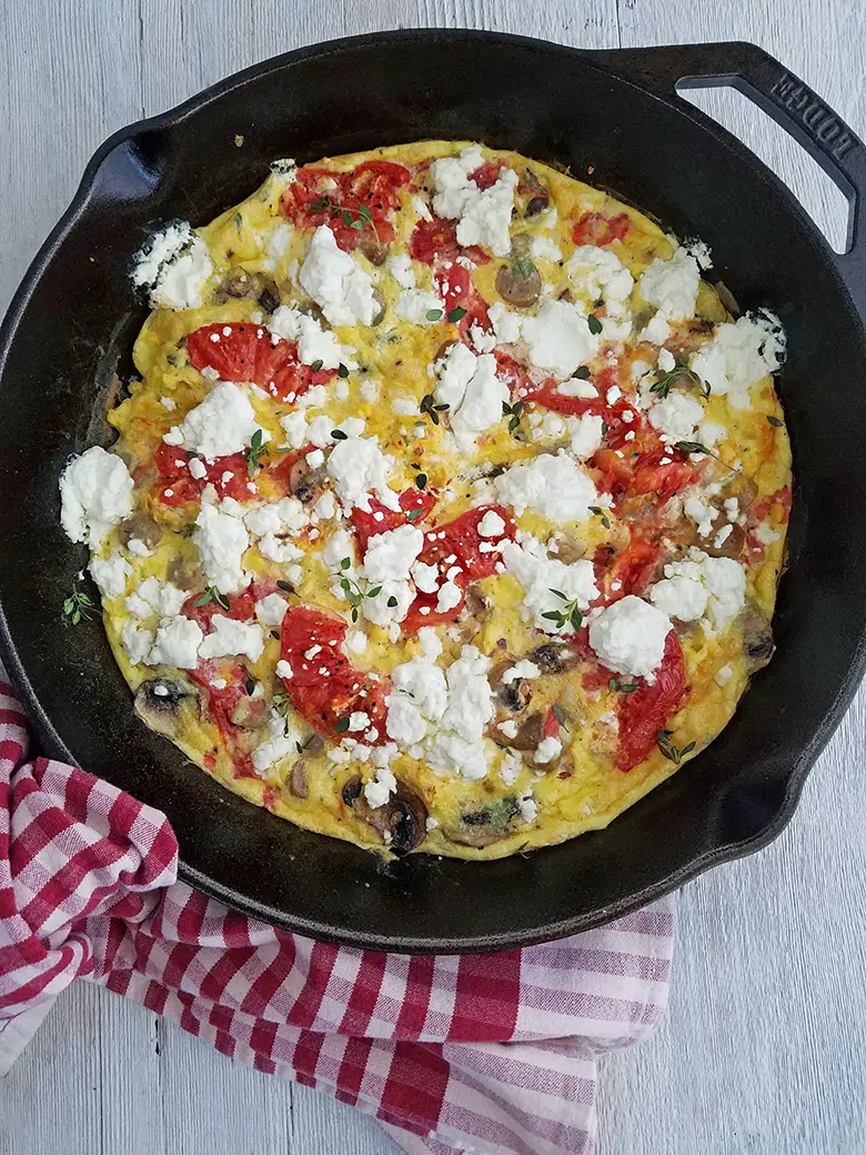 Frittata in cast iron skillet on a red towel