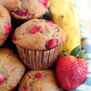 Muffins with strawberries and banana stacked on a towel