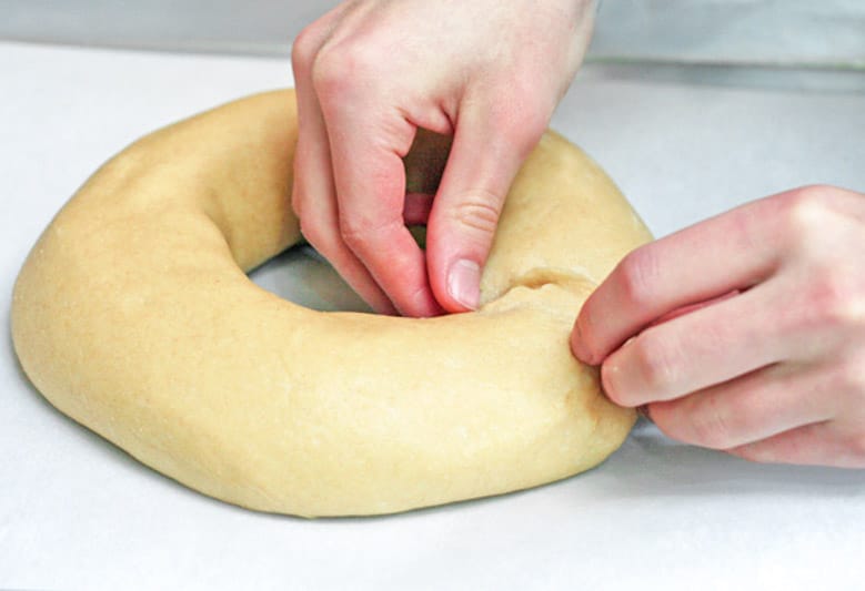 shaping the dough into a ring on a sheet pan lined with parchment