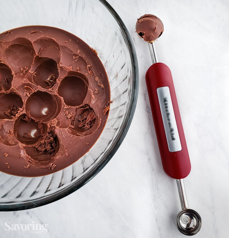 Using a melon baller to scoop and shape chocolate truffles