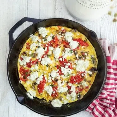 tomato and goat cheese frittata in a cast iron skillet