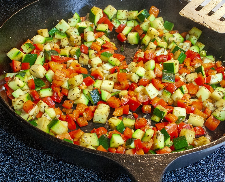 zucchini and red peppers in cast iron skillet