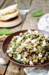 quinoa salad with eggplant and feta on a wood table