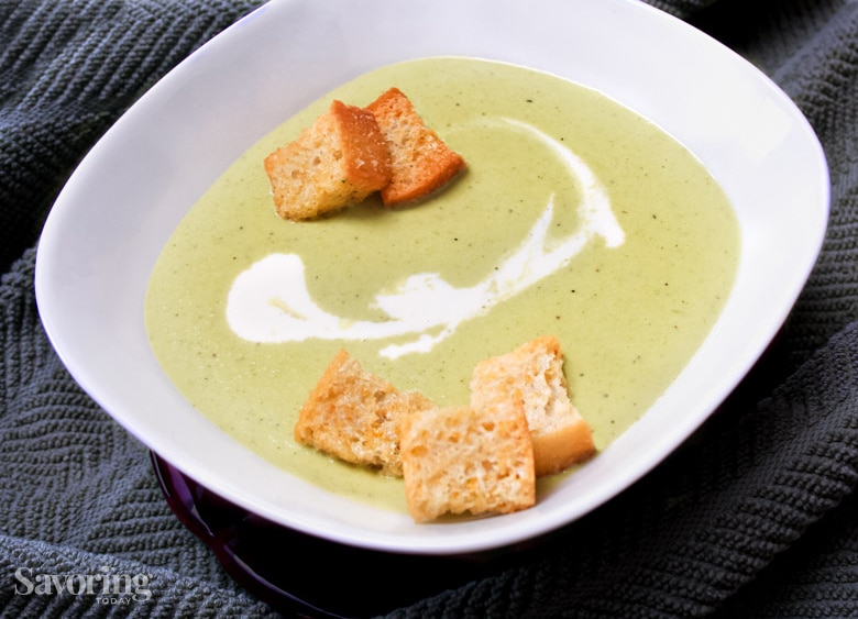 asparagus soup in a white bowl on a grey towel