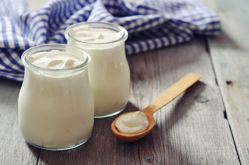 yogurt in a glass jar on a wood table