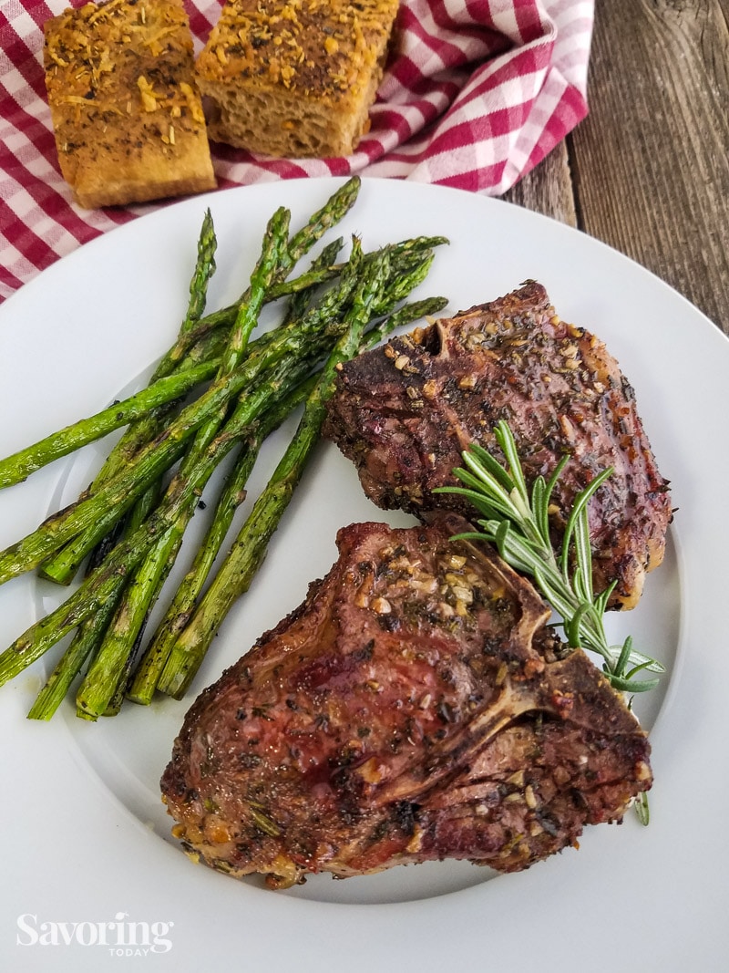 lamp chops served with asparagus on a white plate