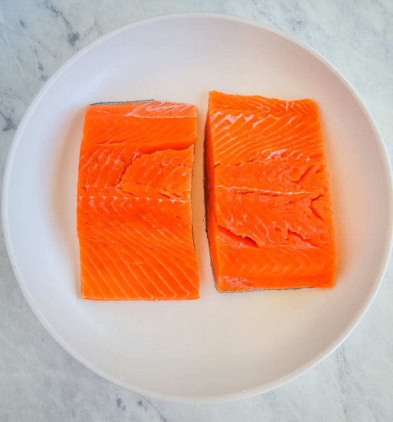 6 ounce salmon fillets on a white plate