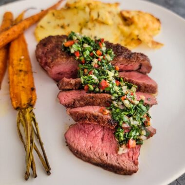Sliced grilled steak with carrots and potatoes