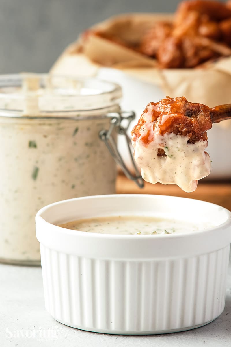 chicken drumstick dipped into ranch dressing