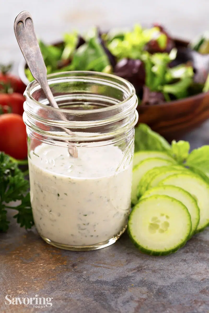 dressing beside cut vegetables and salad