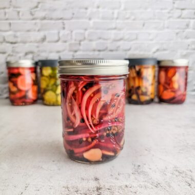 pickled red onions in a jar oon a table