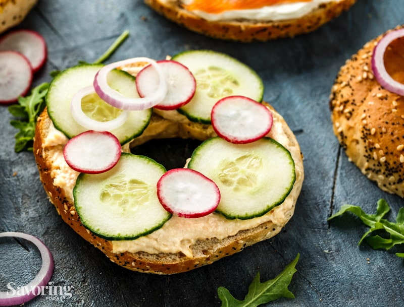 Hummus, radishes and cucumber on a bagel