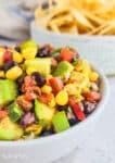 black bean and corn salsa in a white bowl with chips