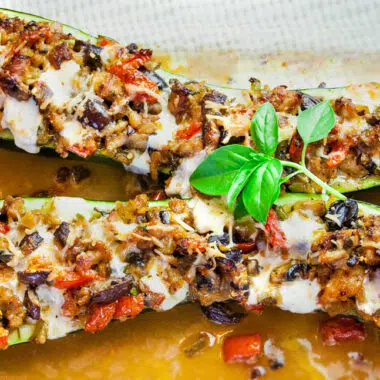 large zucchini stuffed with tomatoes, cheese, and sausage