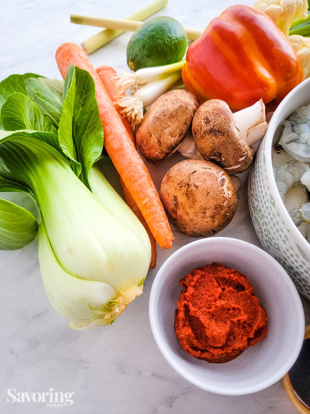 red curry paste beside bok choy, carrots, and mushrooms