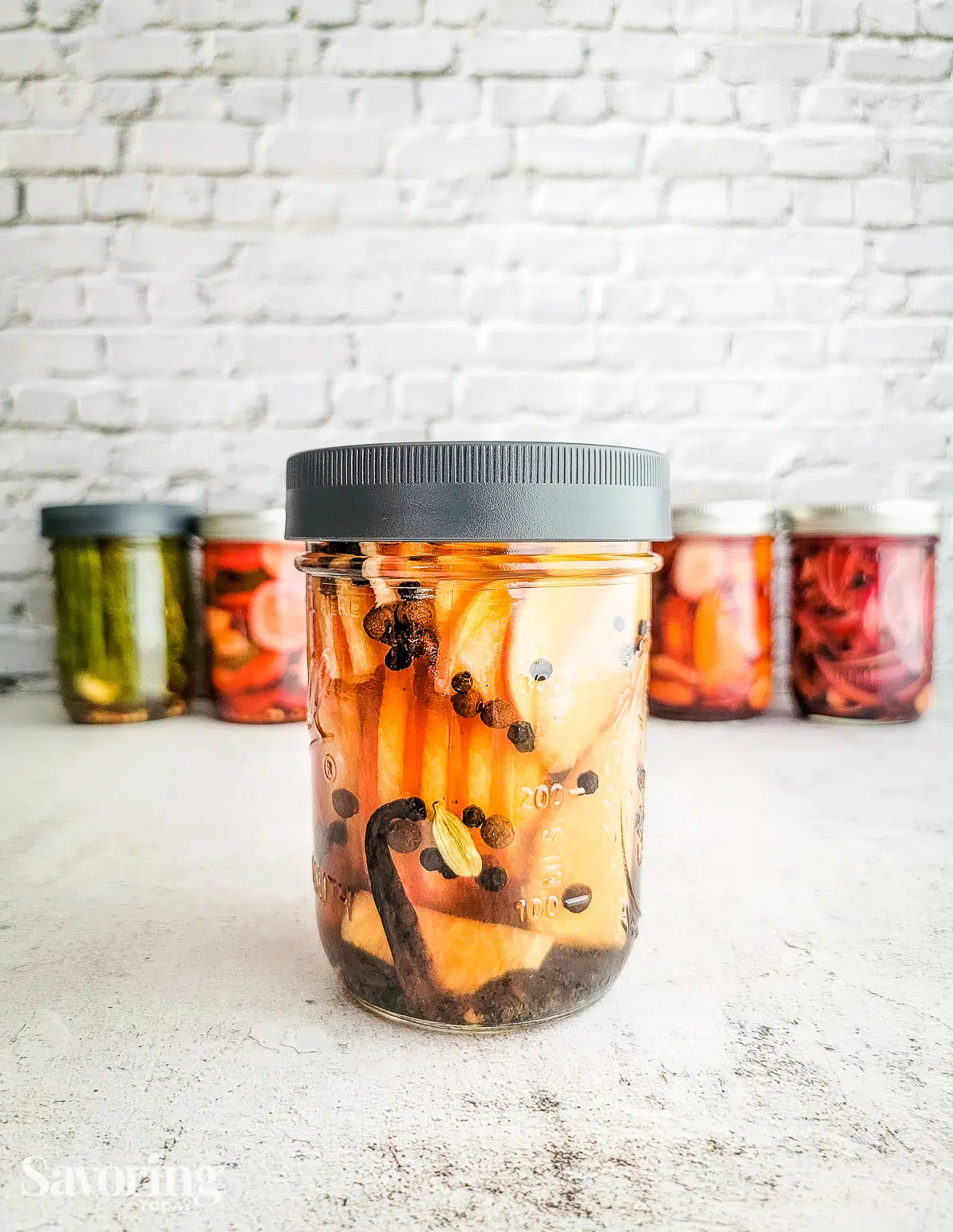 apple jicama pickles on a counter in front of other jars 