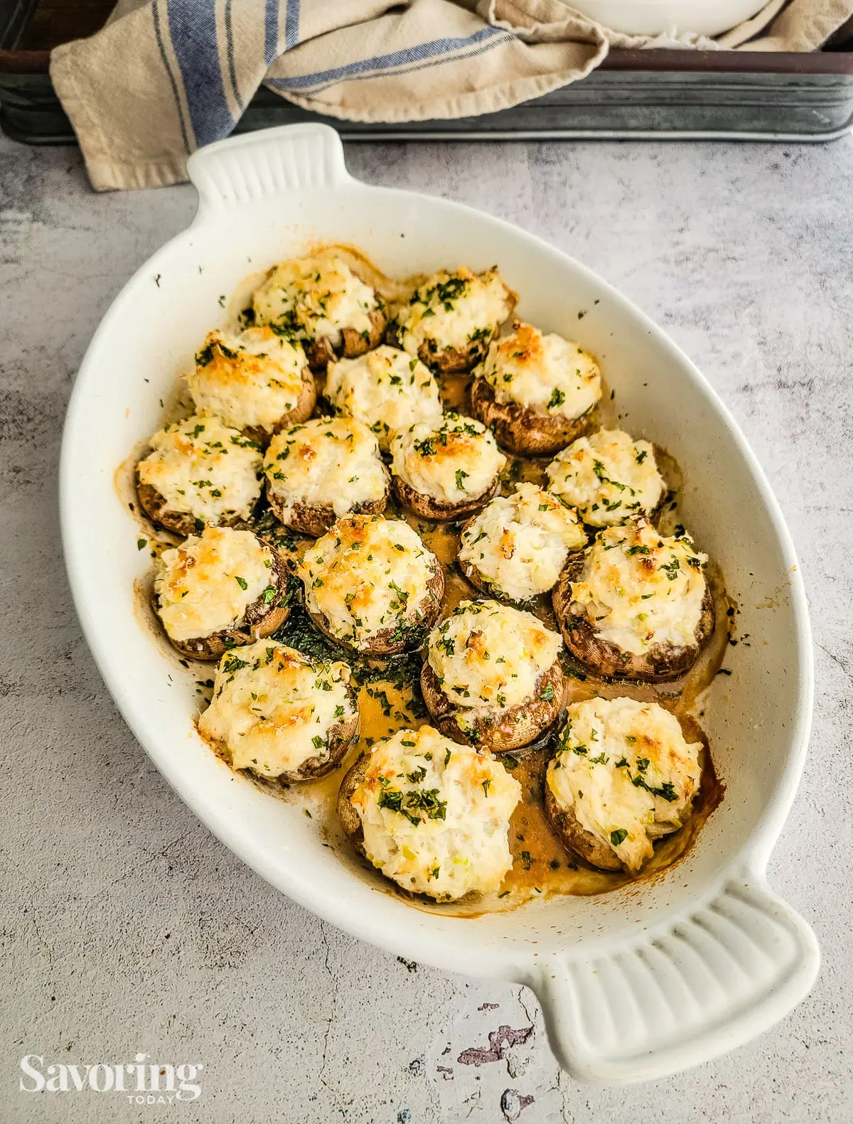 Stuffed mushrooms in a white baking dish on a concrete counter