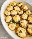 baked crab stuffed mushrooms in a white dish
