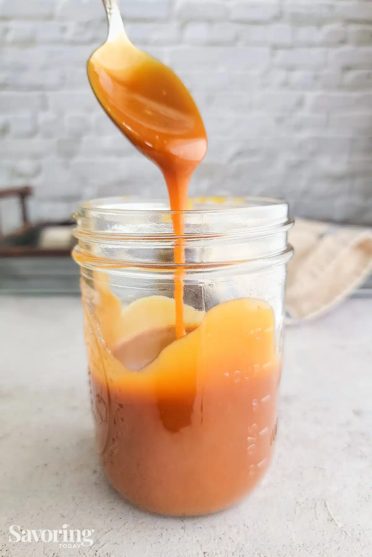 salted caramel sauce running off a spoon into a mason jar