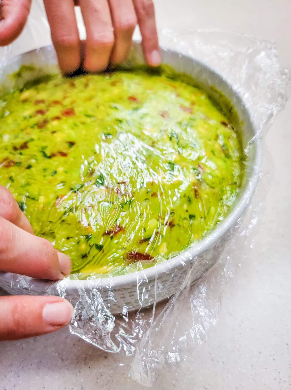 laying plastic wrap over guacamole for storage