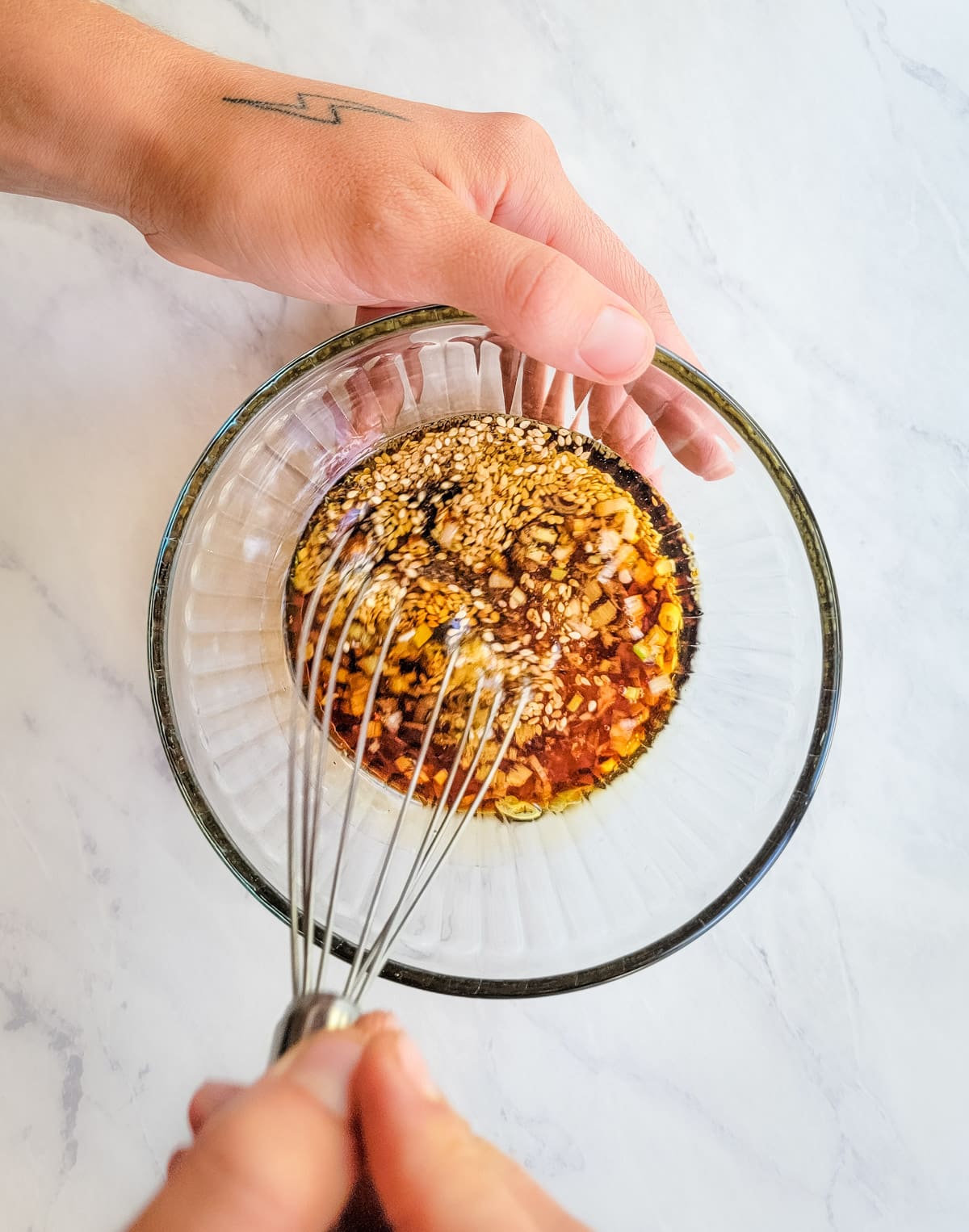 Mixing Asian sesame dressing in a bowl with a whisk