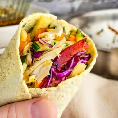 Chicken salad wrapped in a tortilla held in the hand