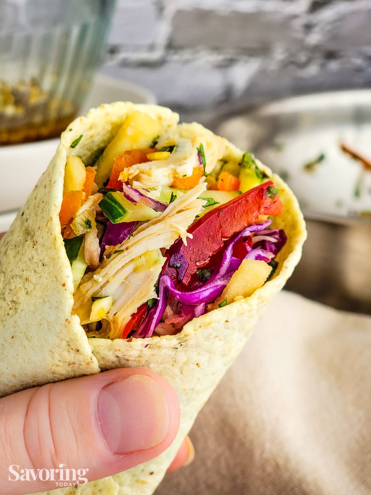 Chicken salad wrapped in a tortilla held in the hand