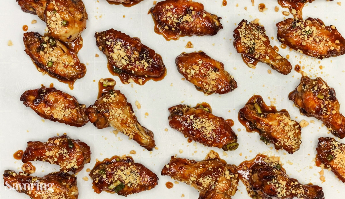chicken wings fresh from the oven on a rimmed baking sheet
