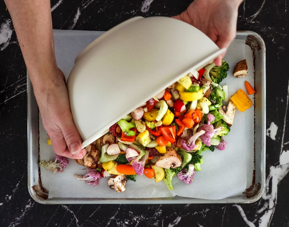 pouring veggies out on a rimmed baking sheet