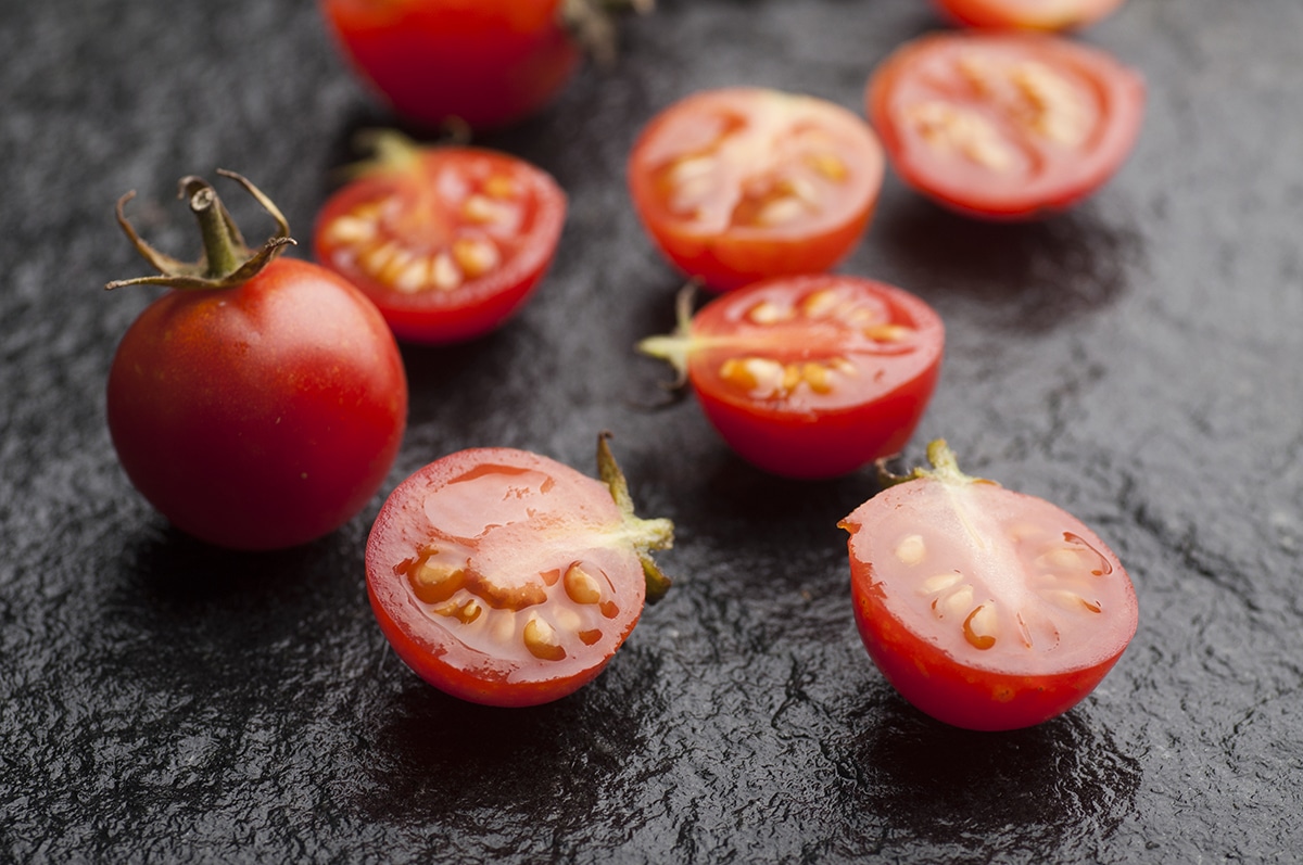 cherry  tomatoes cut in half on slate background