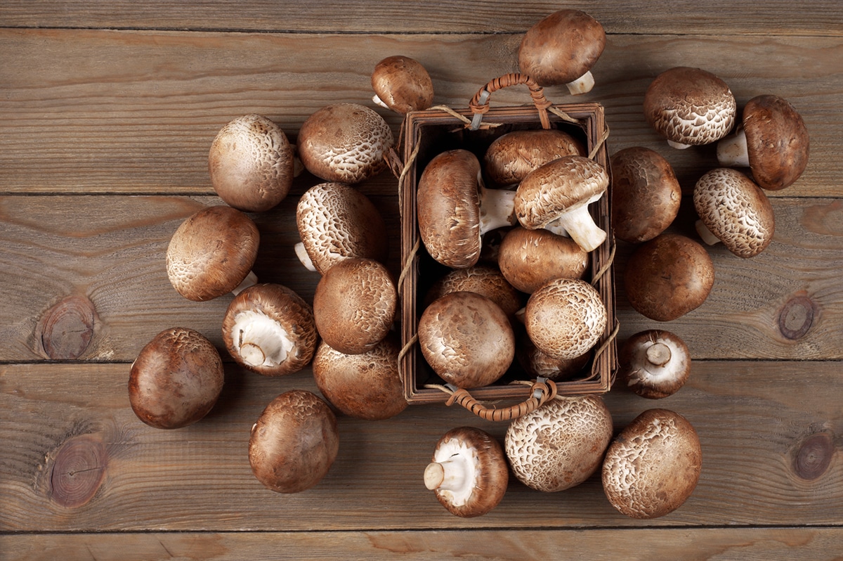 crimini mushrooms on a wood table