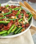 green beans with prosciutto and shallots in a white bowl