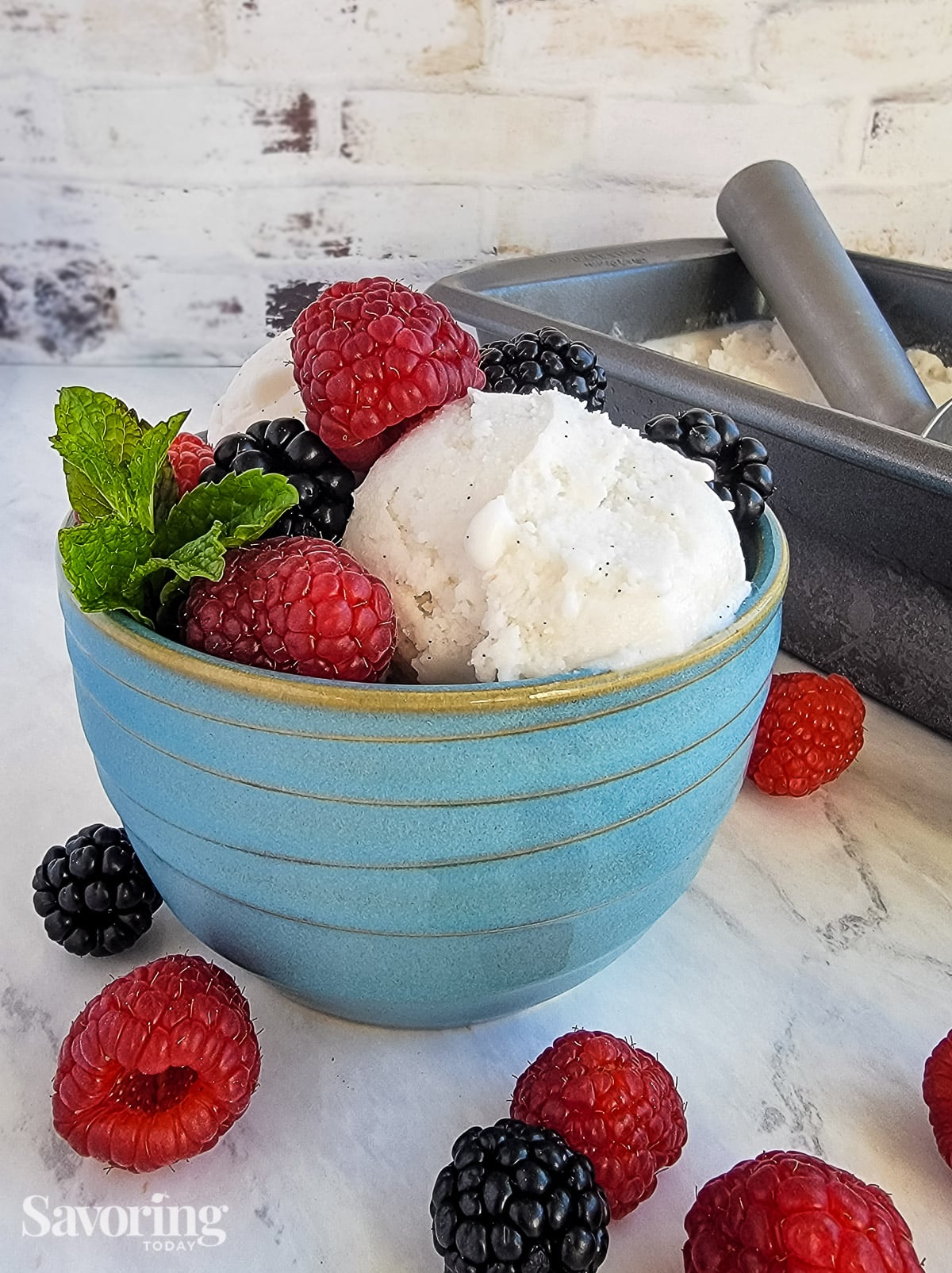 berries and mint on top of a serving of sorbet in a blue bowl