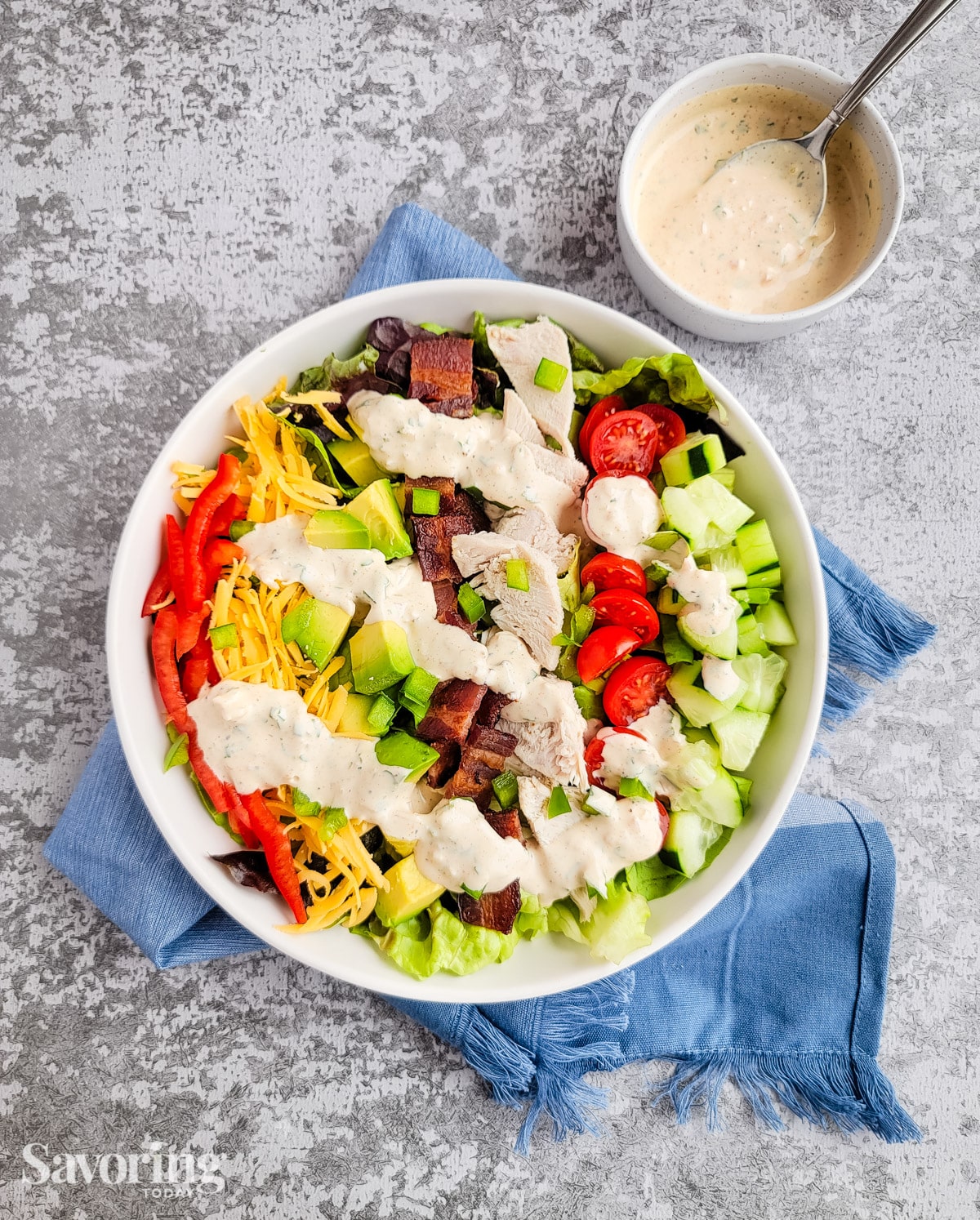 Turkey BLT salad in a white bowl set on a towel 