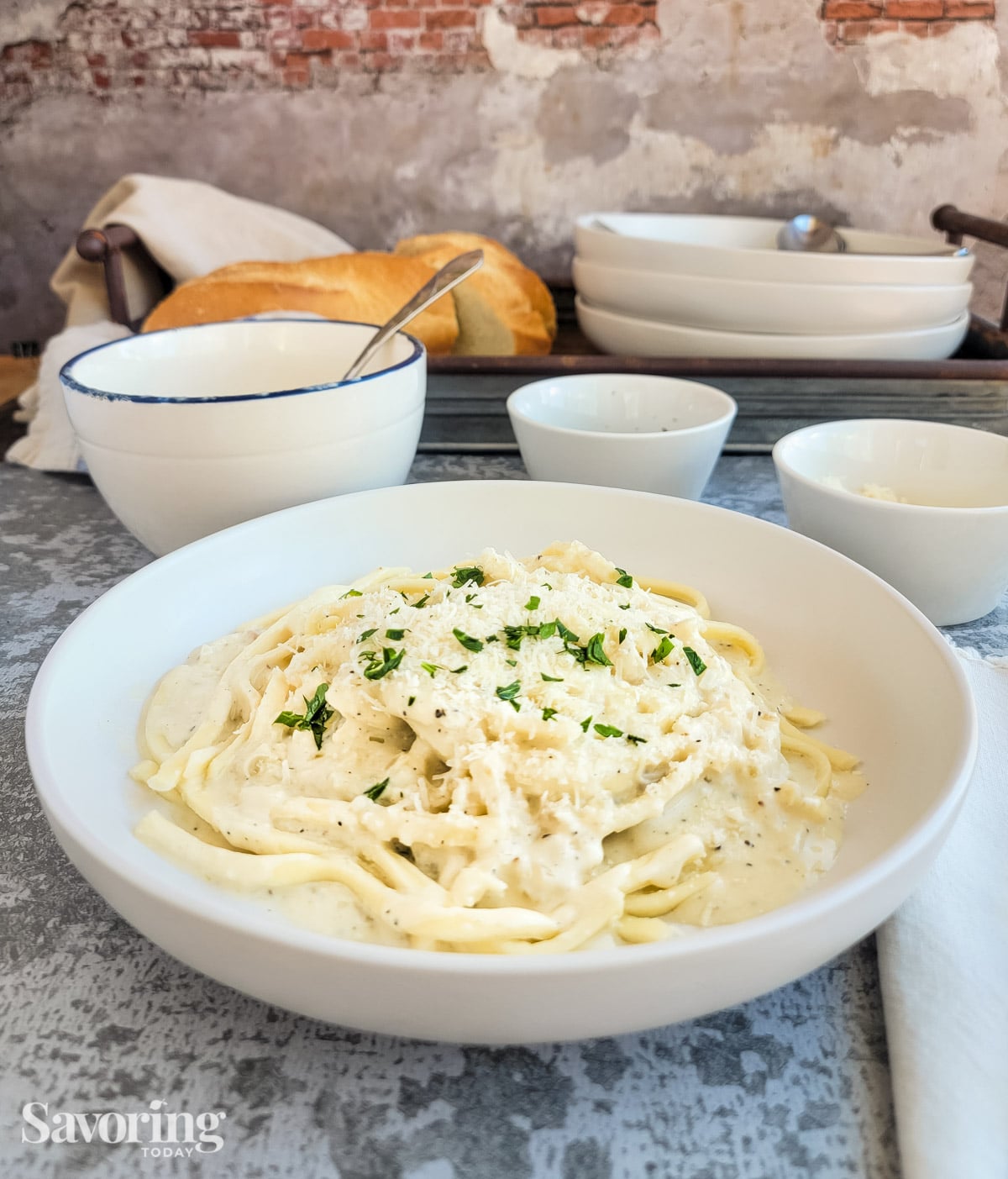 bowl of pasta dressed with alfredo sauce in a white bowl