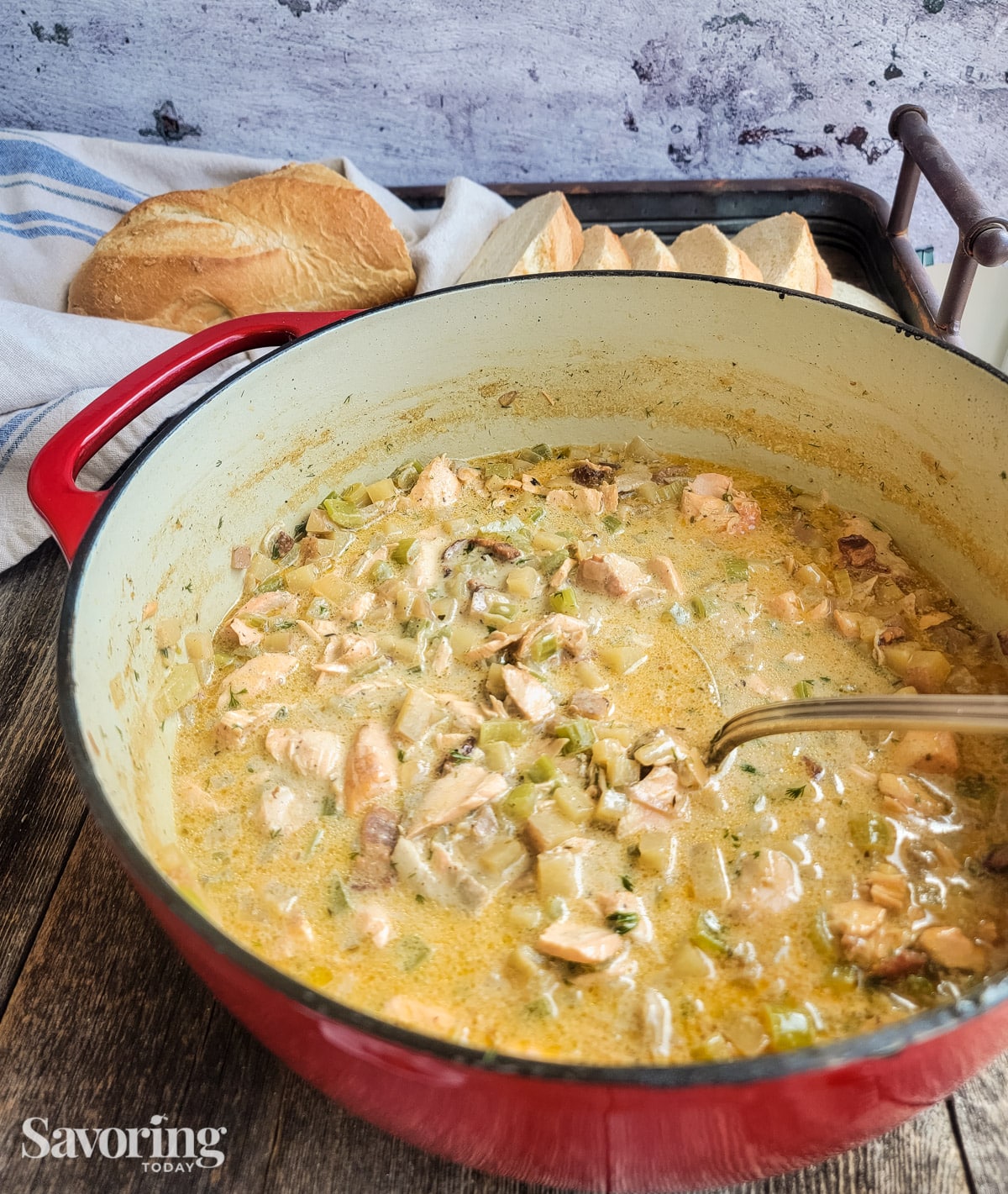 Salmon dill chowder in red pot with bread