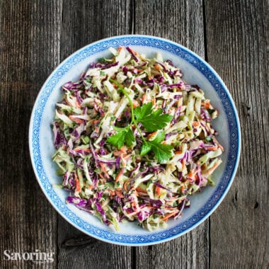 dressed coleslaw in a white bowl with a blue rim