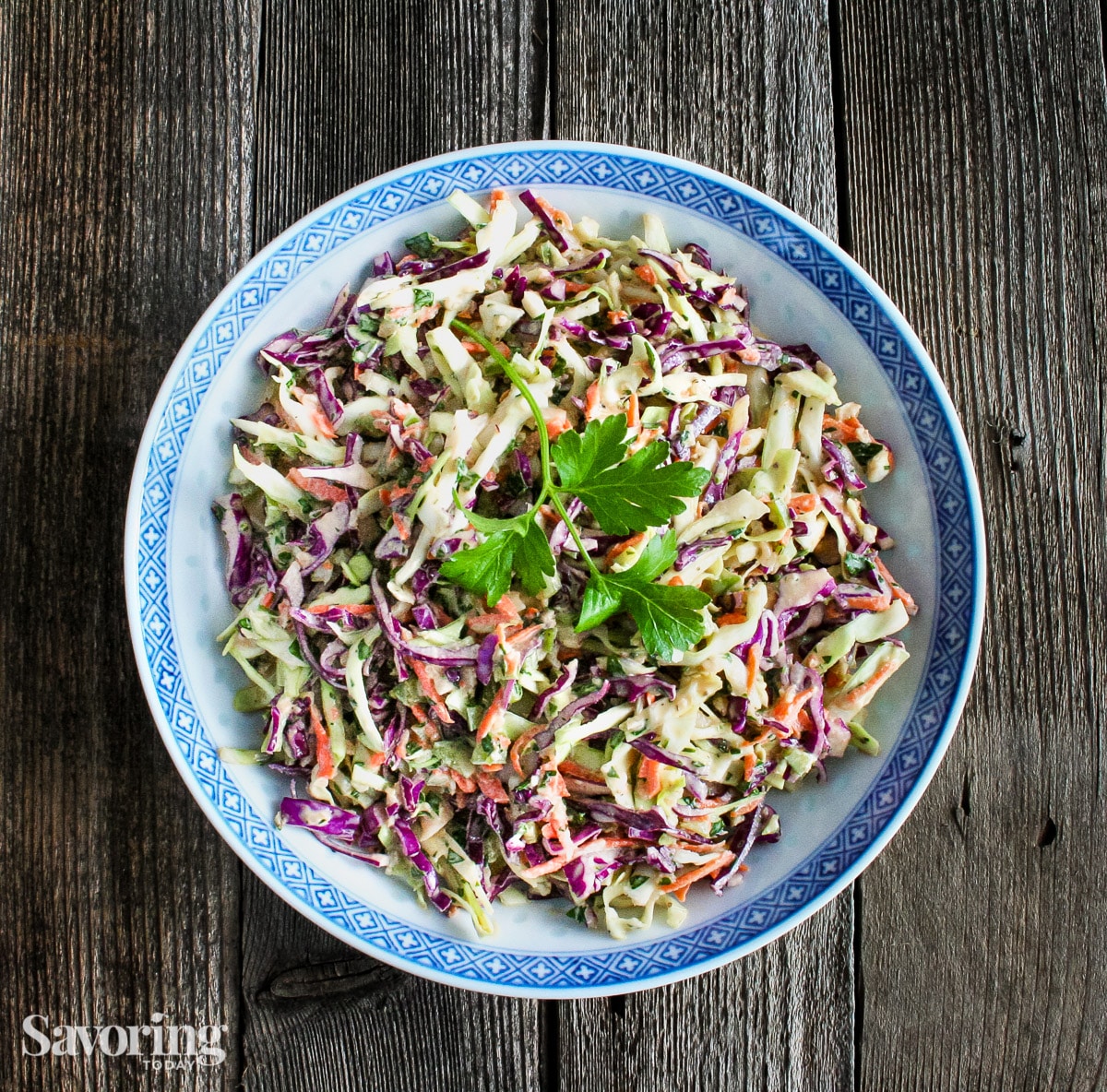 rainbow coleslaw with celery seed dressing in a blue rimmed bowl