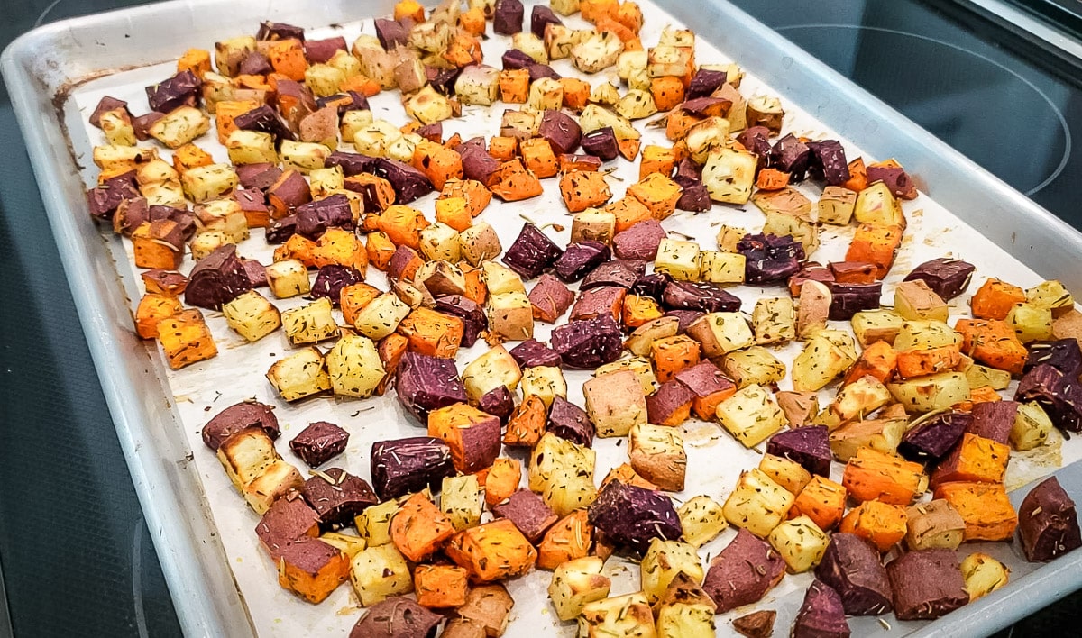 purple, red, and white roasted sweet potatoes on a pan