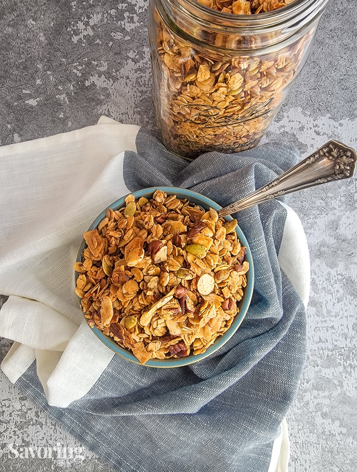 Overhead view of granola in a bowl beside a mason jar