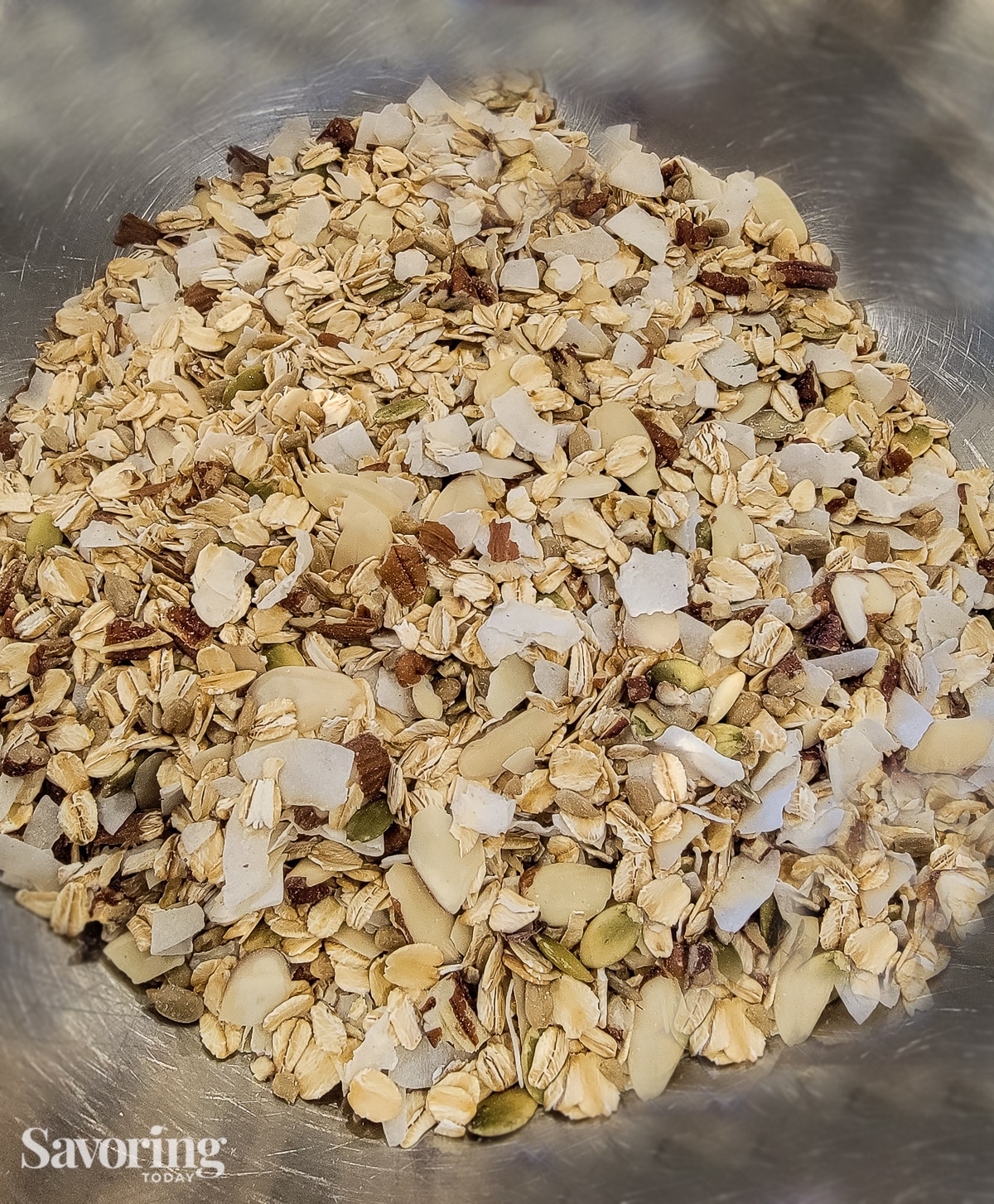Raw granola mixed in a stainless steel bowl