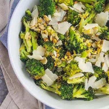 broccoli, parmesan, and pistachios tossed together in a serving bowl